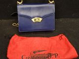 un sac à main violet et bleu et une pochette rouge posés sur un fond noir