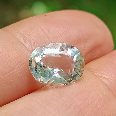 quelqu'un tient dans sa main un diamant vert et blanc