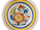 a plate with a flower design on it on a white background
