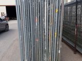 a lot of poles that are sitting in front of a fence