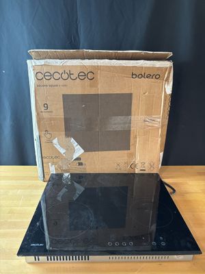 une boîte ouverte contenant un ordinateur portable, posée sur une table en bois