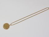 an image of a gold necklace with a sunflower on it