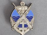 badge with crossed swords and a cross on it on a gray surface
