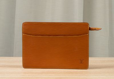 a brown leather wallet sitting on top of a wooden table