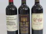 three bottles of wine are lined up on a white surface