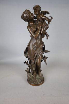 statue en bronze représentant une femme tenant un enfant et un oiseau