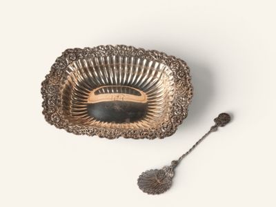 a silver plate with a spoon and a spoon rest on it