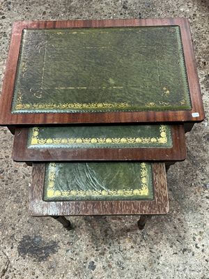 three wooden tables with green covers on them sitting on the ground