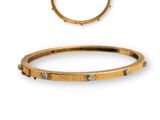 a close up of a gold bracelet and a diamond ring