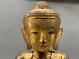 a gold statue of a person with a crown on it ' s head
