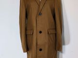 brown wool coat on a mannequin stand on a white background
