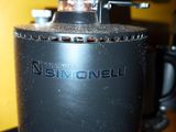 a coffee grinder with coffee beans on top of it
