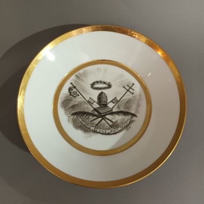 une assiette sur laquelle est représenté un homme et un oiseau