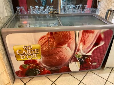 a display case with ice cream and strawberries on it
