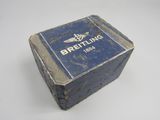 an old blue box with a logo on it sitting on a white surface