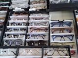 many pairs of glasses sitting in a box on the floor