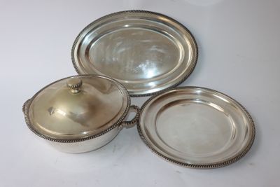 trois plats argentés posés sur une table blanche, recouverts d'un couvercle en argent