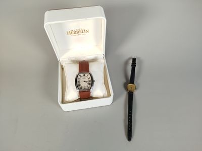 a watch in a box with a pen next to it