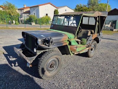 une jeep verte garée sur le gravier