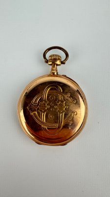 une vieille montre de poche en or sur laquelle figure le portrait d'une femme