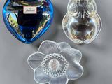 three glass owl figurines sitting next to each other on a table