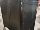 a black cabinet with a mirror on it in the middle of a room