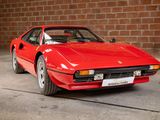 an image of a red sports car parked in front of a brick wall