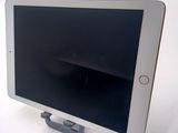 a tablet computer sitting on a stand on a white surface