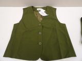 a green vest and tie on a table next to a pair of shoes