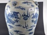 un vase bleu et blanc surmonté d'un oiseau