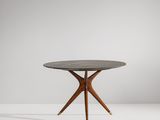 une table ronde avec des pieds en bois et un plateau en marbre noir