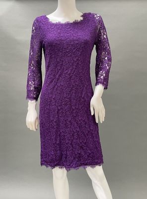 a mannequin wearing a purple lace dress with long sleeves