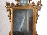 un miroir dans lequel on voit un voilier, accroché au mur
