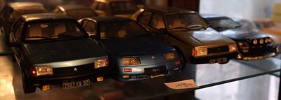 Plusieurs petites voitures sont exposées dans une vitrine.