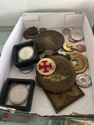 une boîte remplie de pièces et de médailles posée sur une table