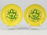 two yellow and green plates with dragon designs on them