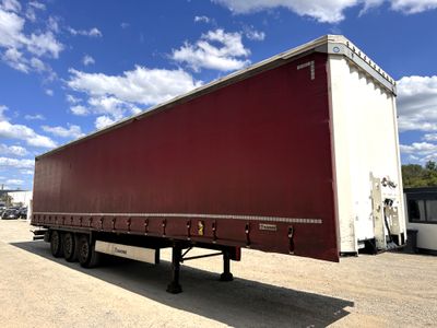 a red semi trailer parked in a parking lot
