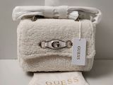 un sac à main blanc et une serviette blanche posés sur une table