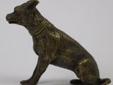 statue of a dog sitting on its hind legs with a collar around it ' s neck
