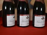 three bottles of wine sitting on a table next to a wooden box