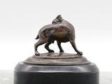 bronze statue of a dog on a marble base on a table