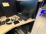 un bureau d'ordinateur sur lequel se trouvent un écran, un clavier et une souris