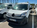 une camionnette blanche garée dans un parking à côté d'autres voitures