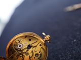 a close up of a pocket watch on a man ' s lapel