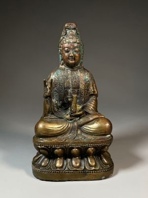 une image représentant une statue en bronze d'un Bouddha assis sur un lotus