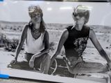a picture of two women sitting on a bench in the desert