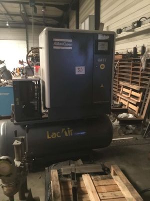 un gros compresseur d'air posé sur une palette dans un entrepôt