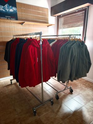a lot of shirts hanging on a rack in a store