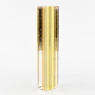 un gros plan sur un grand vase en verre orné d'une bande jaune