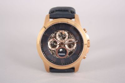 une image d'un gros plan d'une montre-bracelet sur une surface blanche
